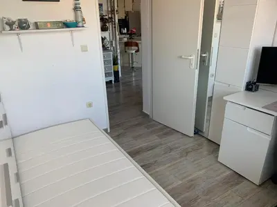 a kitchen with white cabinets and a wooden floor at Seaview Young Family - Семейство на Черно море in Aheloy