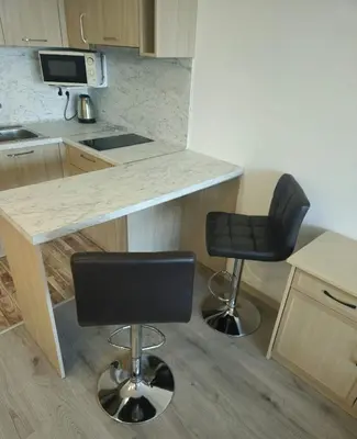 a kitchen with two bar stools and a counter at Apartman RS in Lozenets