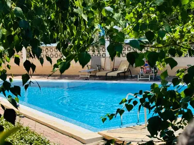 a blue swimming pool with some chairs and trees at ASTORIA II Apartment 12 Sveti Vlas in Elenite