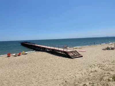 a pier on a beach with people on the beach at ASTORIA II Apartment 12 Sveti Vlas in Elenite