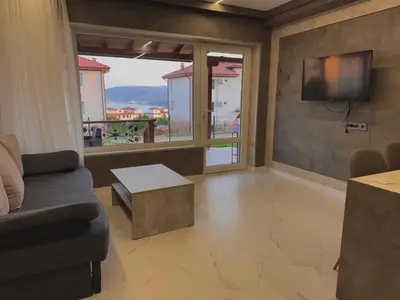 a living room with a couch and a tv at Seagull Apartments in Byala