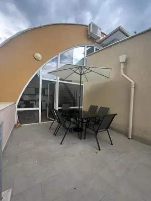 a patio with a table and chairs with an umbrella at Dream holiday Ravda in Ravda