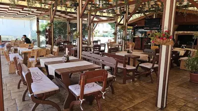 a restaurant with wooden tables and chairs and people at Studio 67 & Apartment 16 Rainbow Holiday Complex in Sunny Beach