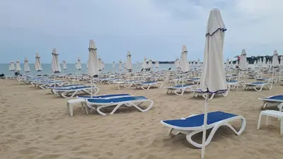 a bunch of chairs and umbrellas on a beach at Studio 67 & Apartment 16 Rainbow Holiday Complex in Sunny Beach