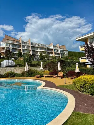 a swimming pool in front of a large apartment building at Sunset Deluxe in Kosharitsa