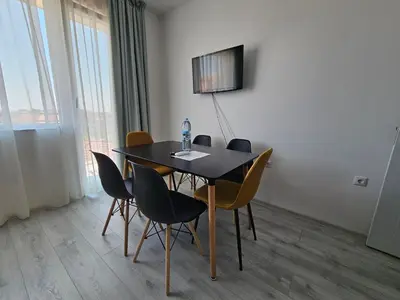 a dining room with a black table and chairs at Естрела къща за гости in Ravda