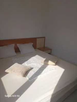 a large white bed with two pillows on it at Апартамент Бяла in Byala