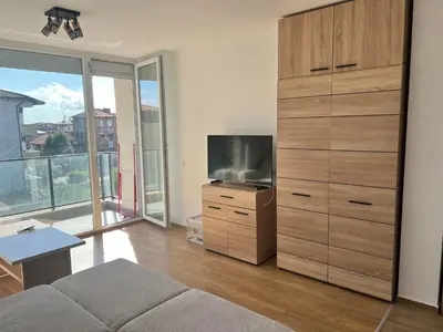 a living room with a large entertainment center with a television at Modern Comfort Studio with Terrace Tsarevo in Tsarevo