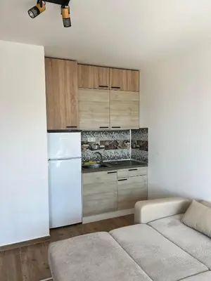 a white kitchen with a white refrigerator and cabinets at Modern Comfort Studio with Terrace Tsarevo in Tsarevo