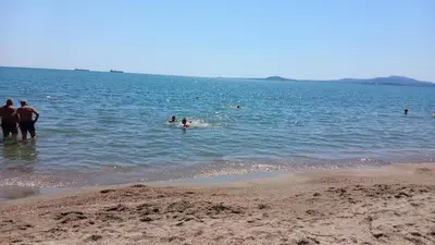 a group of people in the water at the beach at Студио Слънчева перла in Burgas City