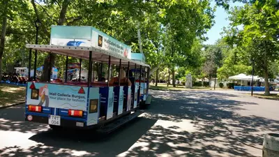 a trolley car driving down a street in a park at Студио Слънчева перла in Burgas City