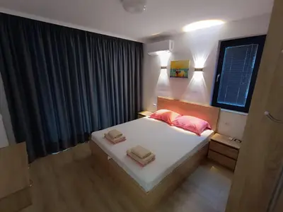 a bedroom with a bed with two pink pillows at Апартамент 10 улица Македония 33 in Pomorie