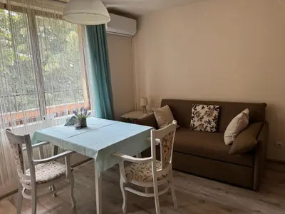 a living room with a table and a couch at Shishkova Garden Apartments in Varna City