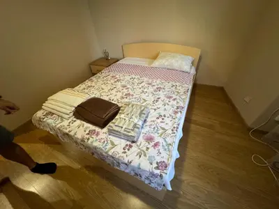 a small bedroom with a bed with a flowered blanket at Shishkova Garden Apartments in Varna City