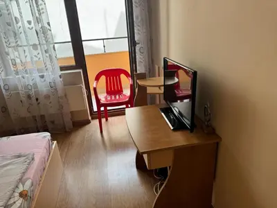 a room with a desk with a computer and a chair at Shishkova Garden Apartments in Varna City