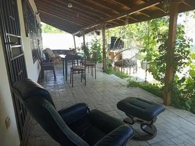 a patio with couches and a table and chairs at Къща за гости Veranda Raia Поморие in Kamenar