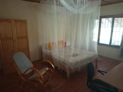 a bedroom with a bed and a table and chairs at Къща за гости Veranda Raia Поморие in Kamenar