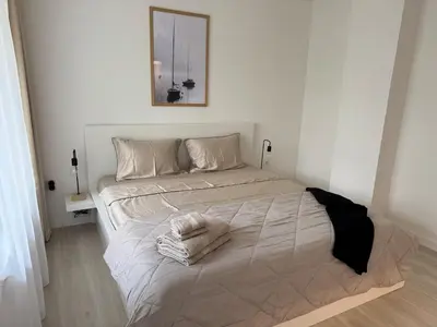 a white bedroom with a bed with towels on it at Summer Apartment in Burgas City