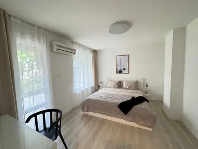a bedroom with a bed and a table in it at Summer Apartment in Burgas City