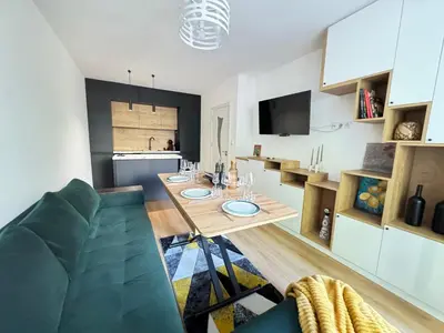 a dining room and kitchen with a table and a couch at Infinity Apartament in Burgas City