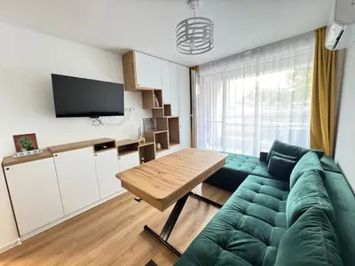 a living room with a green couch and a table at Infinity Apartament in Burgas City