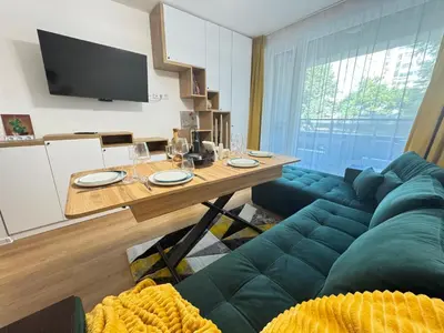 a living room with a table and a couch at Infinity Apartament in Burgas City