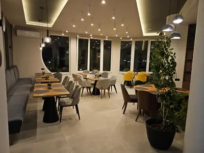 a restaurant with tables and chairs and lights at Hotel Sea Sand in Sveti Vlas