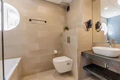 a bathroom with a toilet and a sink and a tub at Hotel Sea Sand in Sveti Vlas