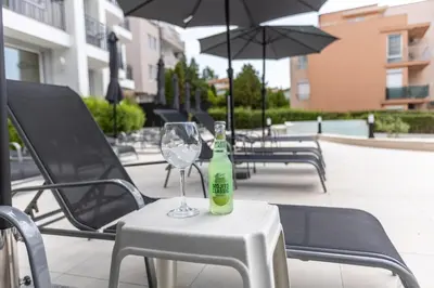 a bottle of wine sitting on a table with a glass at Hotel Sea Sand in Sveti Vlas