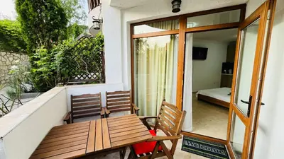 a porch with a wooden bench and a bed at FREGATA STUDIO 4 Sveti Vlas in Sveti Vlas