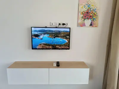 a flat screen tv hanging on a white wall at Апартамент 11 улица Македония 33 Поморие in Pomorie