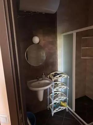a bathroom with a sink and a mirror and a shelf at Центр солнечного берега in Sunny Beach