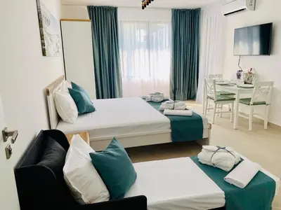 a hotel room with two beds and a table at BAMBOO BEACH STUDIO- Sozopol in Sozopol