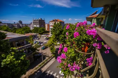 a balcony with purple flowers on a city street at Guest House ,, Ekaterina