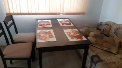 a table with three paintings on it with a chair and a table with a table at Villa Victory Apartments in Nesebar