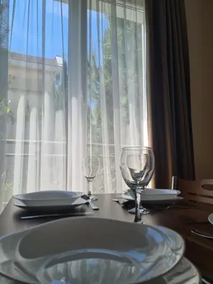a table with two wine glasses and a window at Messembria Palace in Sunny Beach