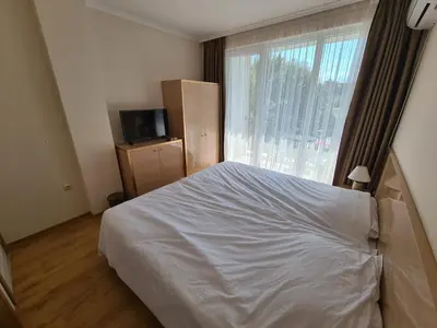 a bedroom with a white bed and a window at Messembria Palace in Sunny Beach