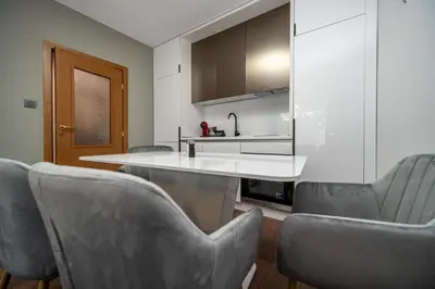 a kitchen with gray chairs and a white counter at Apartment D9 Yassen HV in Sunny Beach