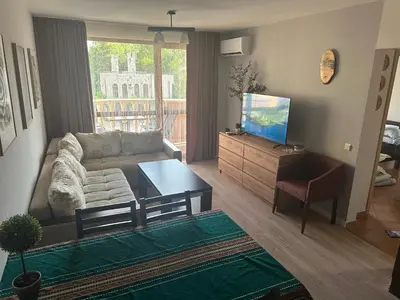 a living room with a couch and a television at Kalia A7 Sunny Beach in Sunny Beach
