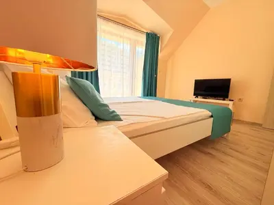 a hotel room with a bed and a television at ViolaSuite in Varna South Bay by RV Apartments in Varna City