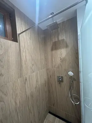 a shower in a bathroom with a wooden wall at VIP Anvers Villa 50 in Elenite