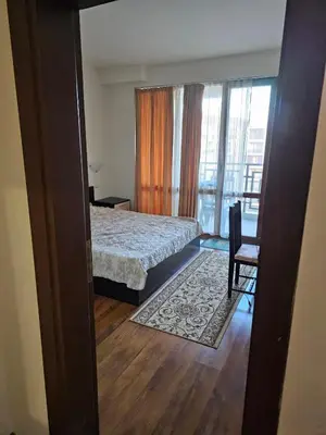 a bedroom with a bed and a chair and a window at Двокімнатна квартира у Panorama Bay 2 в Святому Власі Болгарія in Sveti Vlas
