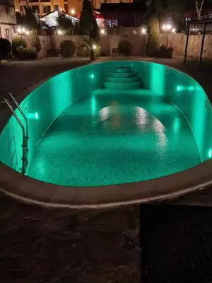 a green swimming pool at night with lights at Двокімнатна квартира у Panorama Bay 2 в Святому Власі Болгарія in Sveti Vlas