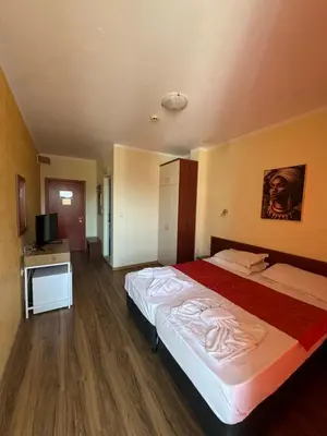 a hotel room with a large bed and a television at HOLIDAY Suites at Sunny Beach in Sunny Beach