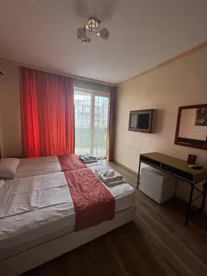 a bedroom with a bed and a desk and a window at HOLIDAY Suites at Sunny Beach in Sunny Beach