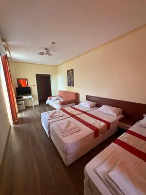 a hotel room with three beds and a piano at HOLIDAY Suites at Sunny Beach in Sunny Beach