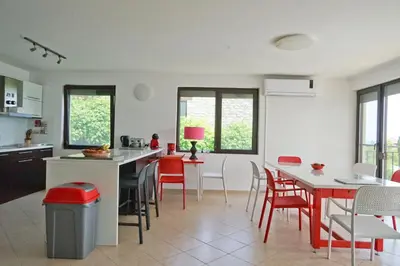 a kitchen with red and white chairs and tables at Six bedroom luxury villa with private pool in quiet residential area near beaches in Sozopol