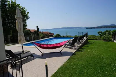 a hammock is sitting next to a swimming pool at Six bedroom luxury villa with private pool in quiet residential area near beaches in Sozopol