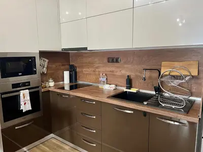 a kitchen with white cabinets and a sink and a stove at Urban Nest Varna - Near Center and Bus Station in Varna City