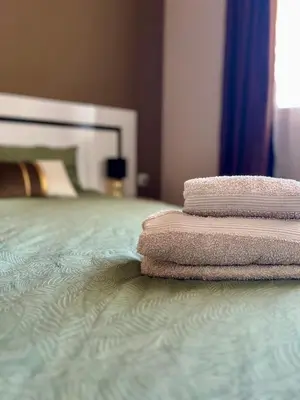 three towels stacked on a bed in a bedroom at Urban Nest Varna - Near Center and Bus Station in Varna City
